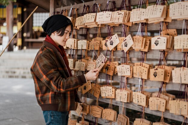 Vista lateral de um homem olhando para cartas de madeira japonesas