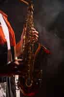 Foto grátis vista lateral de um homem tocando saxofone em destaque