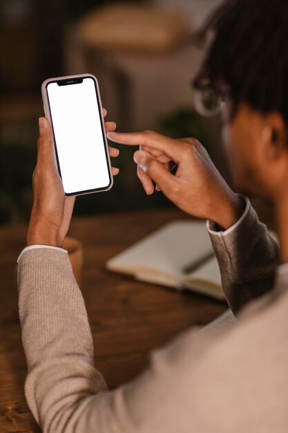 Vista lateral de um homem usando smartphone moderno em casa