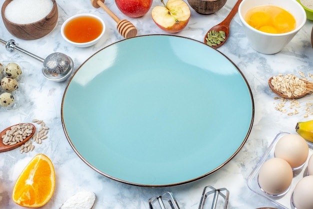 Vista lateral de um prato azul vazio e ingredientes para alimentos saudáveis colocados na superfície do gelo