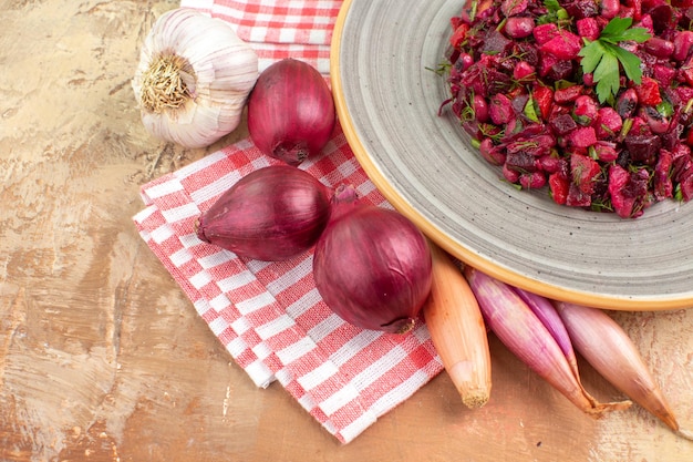 Foto grátis vista lateral de um prato de salada vermelha com verduras em um fundo de madeira