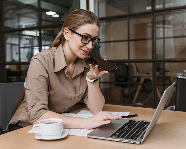 Foto grátis vista lateral de uma jovem empresária falando ao telefone durante uma reunião