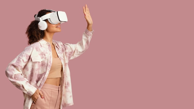 Vista lateral de uma mulher sorridente com fone de ouvido de realidade virtual e espaço de cópia