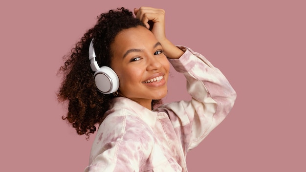 Foto grátis vista lateral de uma mulher sorridente com fones de ouvido
