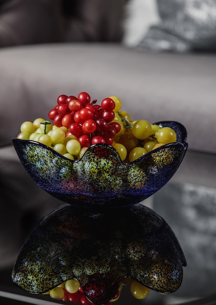 Foto grátis vista lateral de uvas em um vaso de vidro em cima da mesa