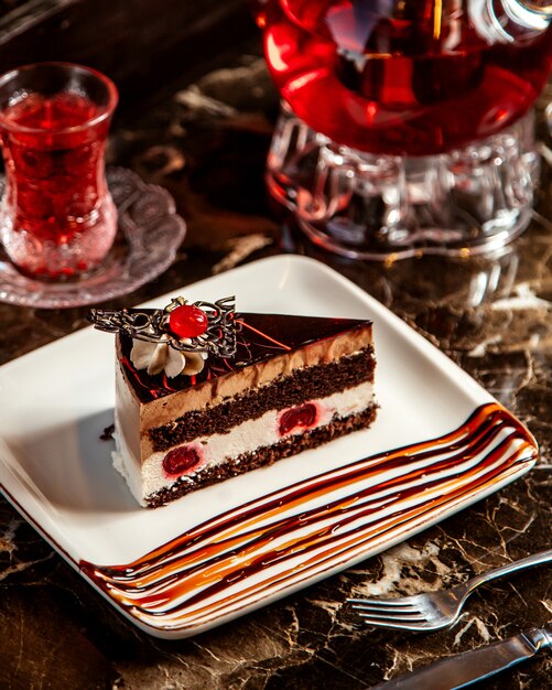 Vista lateral do bolo de chocolate com cerejas no prato