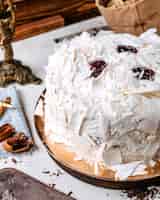 Foto grátis vista lateral do bolo decorado com pedaços de chocolate brancos em cima da mesa