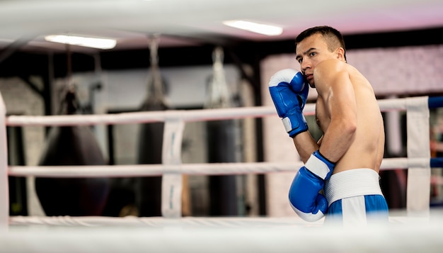 Foto grátis vista lateral do boxer masculino praticando no ringue