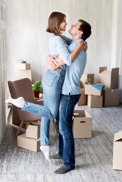 Foto grátis vista lateral do casal abraçado em casa no dia da mudança