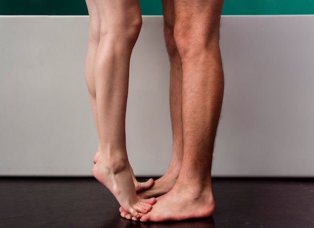 Vista lateral do casal com os pés descalços no banheiro