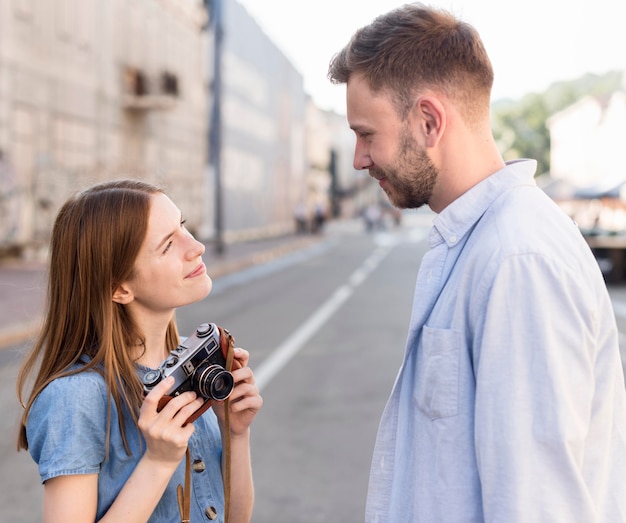 Foto grátis vista lateral do casal de turistas ao ar livre com câmera