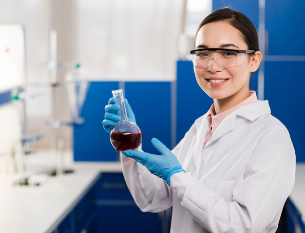 Vista lateral do cientista feminina segurando substância de laboratório