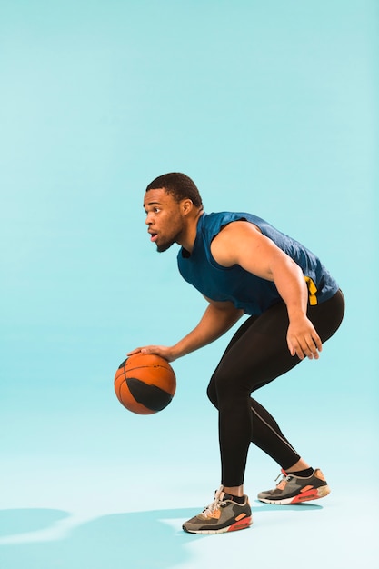 Vista lateral do homem atlético jogando basquete