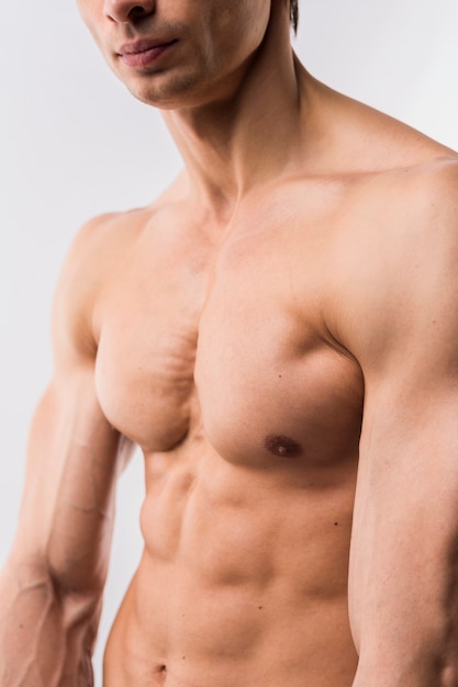 Vista lateral do homem atlético sem camisa, mostrando o corpo musculoso