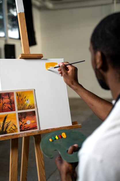 Foto grátis vista lateral do homem pintando em lona