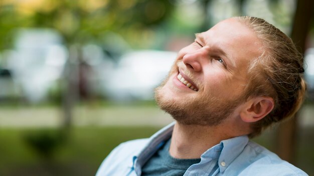 Vista lateral do homem sorridente ao ar livre com espaço de cópia
