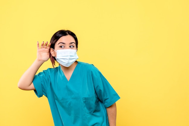Vista lateral do médico em uma máscara ouve reclamações de pacientes com coronavírus