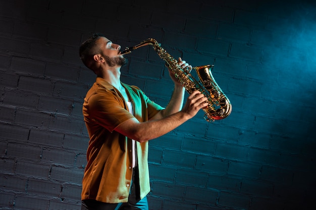 Vista lateral do músico tocando saxofone com espaço de cópia