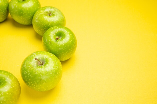 Vista lateral em close-up maçãs maçãs verdes dispostas em um círculo sobre a mesa