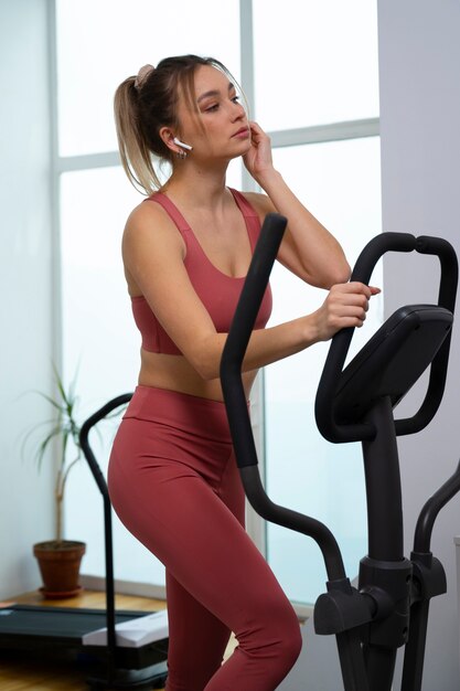Vista lateral em forma de mulher se exercitando em casa