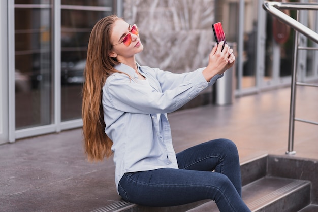 Vista lateral feminino tendo selfies