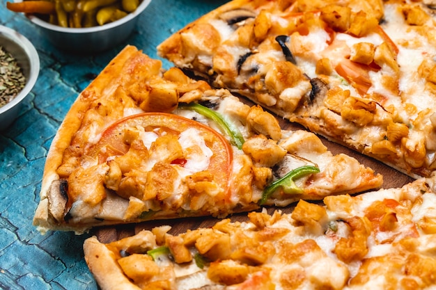 Foto grátis vista lateral frango pizza frango grelhado com tomate fatiado cogumelos queijo e pimentão