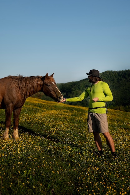 Foto grátis vista lateral homem alimentando cavalo