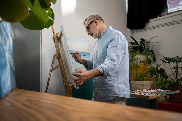 Foto grátis vista lateral homem pintando em casa