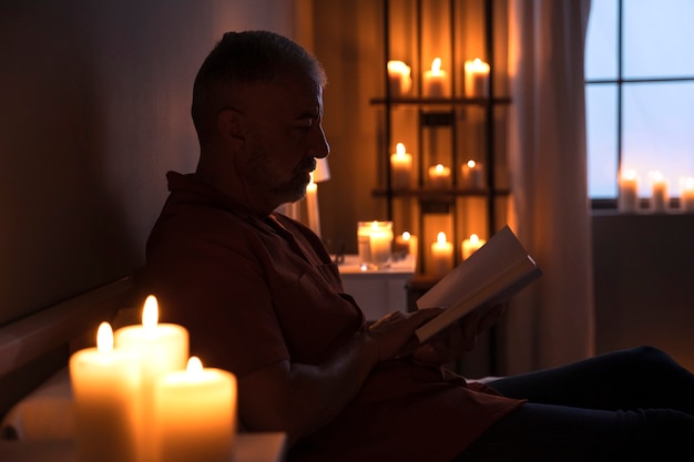 Foto grátis vista lateral homem sênior lendo em casa