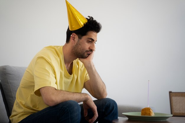 Vista lateral homem triste comemorando aniversário sozinho