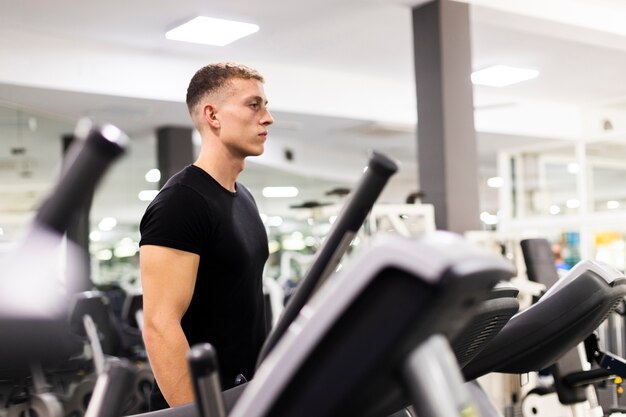 Vista lateral jovem macho em treinamento de ginástica