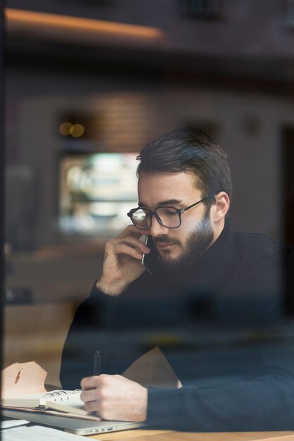 Foto grátis vista lateral jovem macho falando por telefone