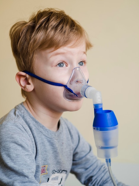 Vista lateral menino com máscara de oxigênio
