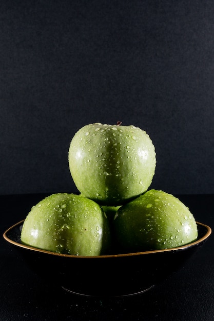 Foto grátis vista lateral molhada maçãs verdes em tigela
