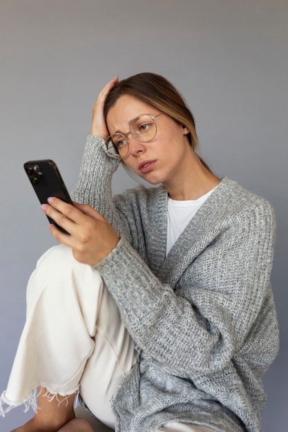 Foto grátis vista lateral mulher ansiosa segurando smartphone