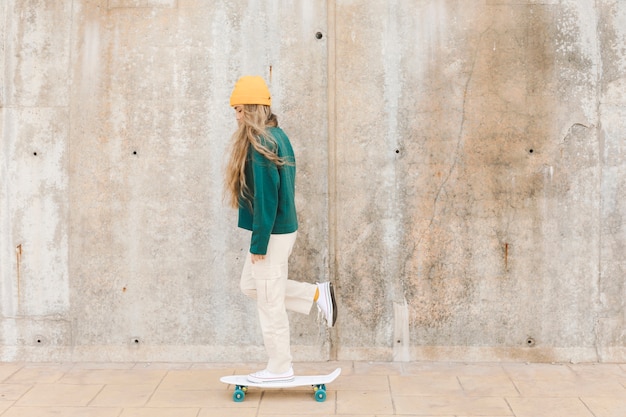 Vista lateral mulher com skate ao ar livre