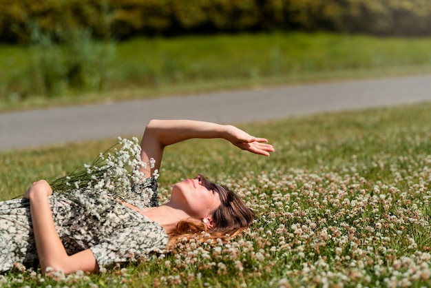 Vista lateral mulher deitada na grama