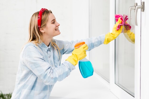 Vista lateral mulher limpando janelas