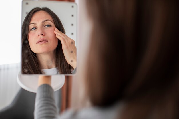Vista lateral mulher olhando no espelho