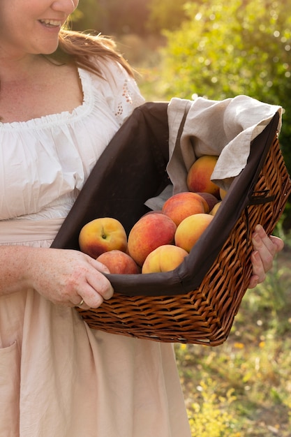 Foto grátis vista lateral mulher segurando cesta de frutas