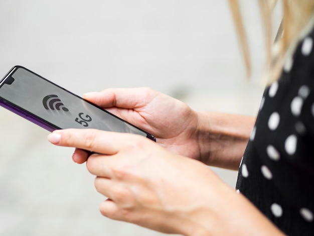 Vista lateral mulher segurando o telefone nas mãos