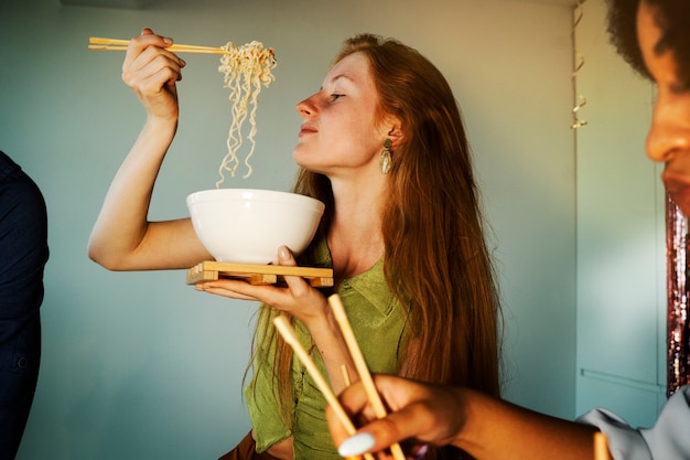 Foto grátis vista lateral mulheres comendo macarrão