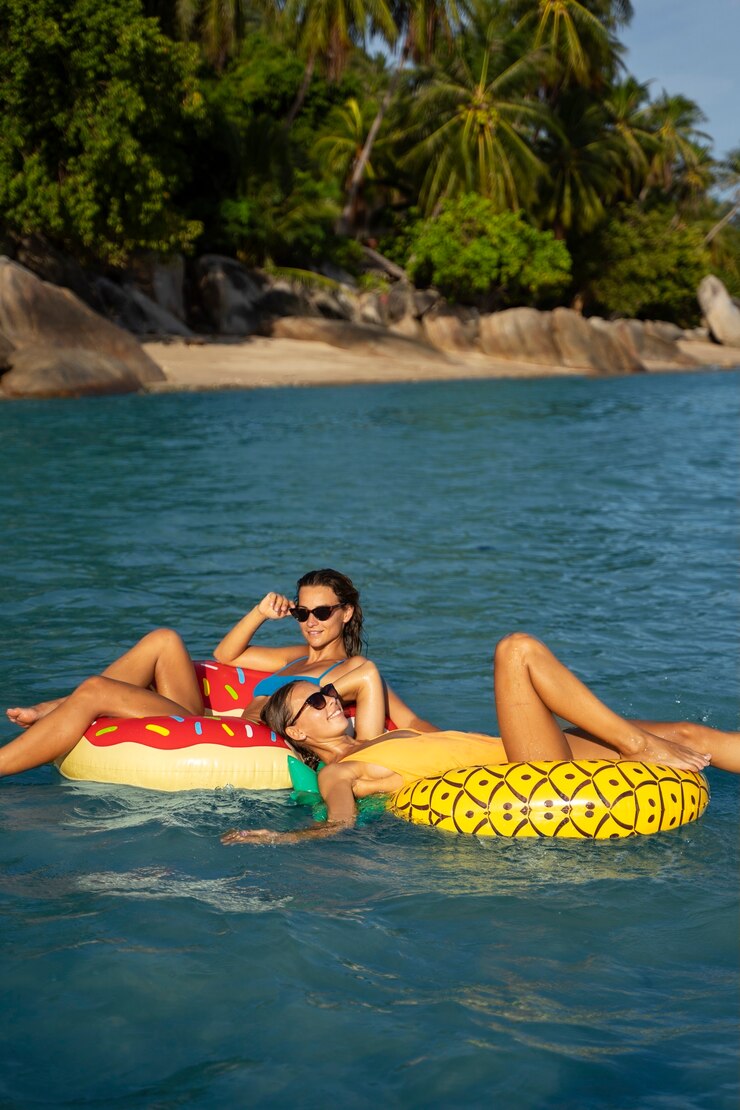 Foto grátis vista lateral mulheres deitadas em flutuadores