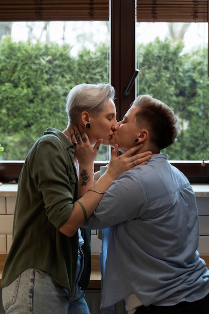 Foto grátis vista lateral mulheres em casa se beijando