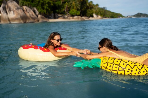 Vista lateral mulheres em flutuadores ao ar livre