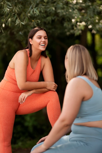 Vista lateral mulheres rindo ao ar livre