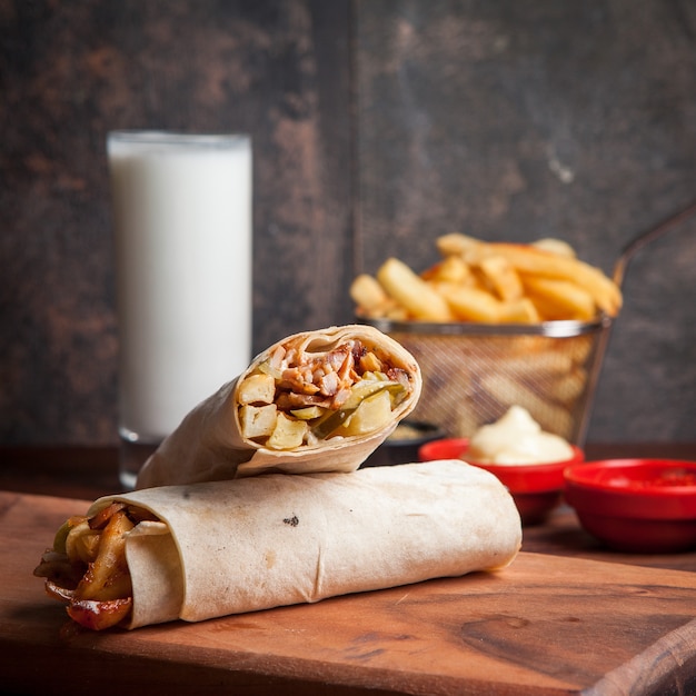 Vista lateral shawarma com batatas fritas e ayran e maionese em panelas