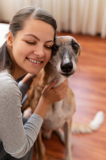 Foto grátis vista lateral sorridente mulher abraçando cachorro