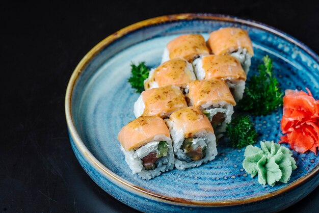 Vista lateral sushi rolos Filadélfia com abacate e wasabi em um prato