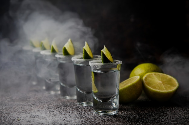 Vista lateral tequila em um copo servido com limão e sal